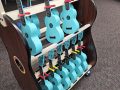 shelves holding blue ukuleles made by Kala