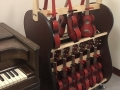 red ukuleles on shelves next to a piano