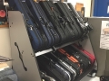 side view of shelf holding violin cases, underneath a bulletin board