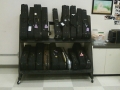 A grainy photo of black violin cases on a rolling shelf system on a tiled floor
